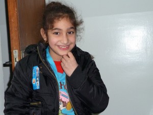 Khalil's daughter proudly shows off her new winter coat - a Christmas gift from CSI supporters.