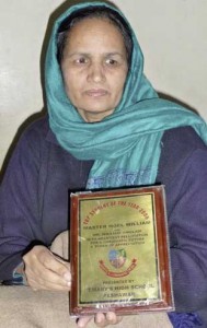Fehmida holds one of the awards her medical student earned before he was killed in a massacre at their church.